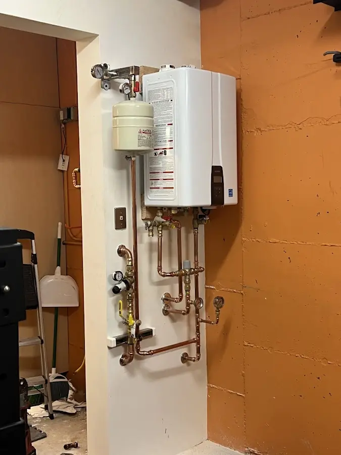 Plumbing technician inspecting water heater connections in Norwalk